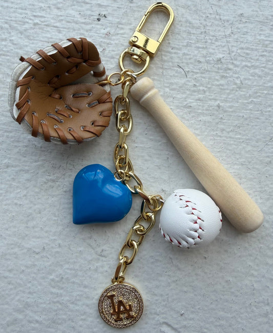 Keychain with baseball-themed charms including a bat, ball, heart, and LA Dodgers logo on a light gray background.