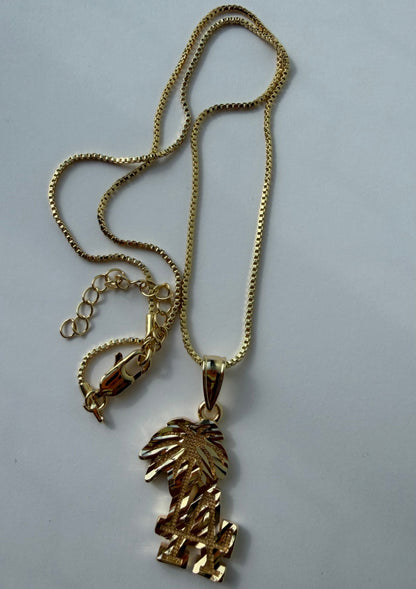 A gold-tone chain necklace with a textured, leaf-like pendant, displayed on a plain light gray background.